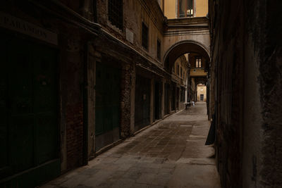 Alley amidst old buildings at night
