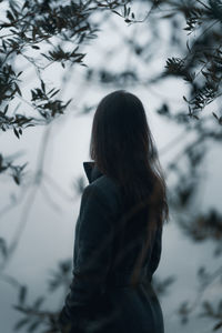 Rear view of woman looking at view against fog