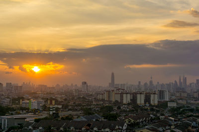 View of cityscape against cloudy sky during sunset