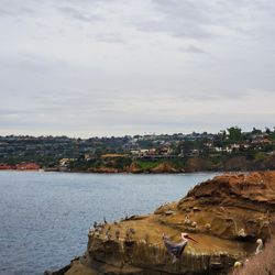 Scenic view of sea by buildings against sky