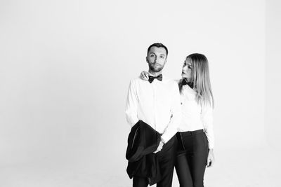 Elegant couple standing against white background