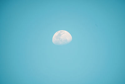 Low angle view of moon against blue sky at night