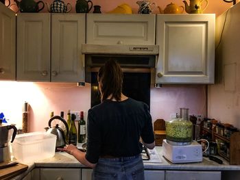 Rear view of woman cooking in kitchen at home