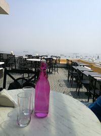 Chairs and tables at sidewalk cafe against clear sky