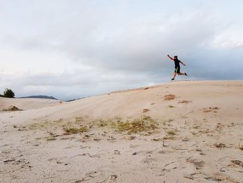 Side view of man on land against sky