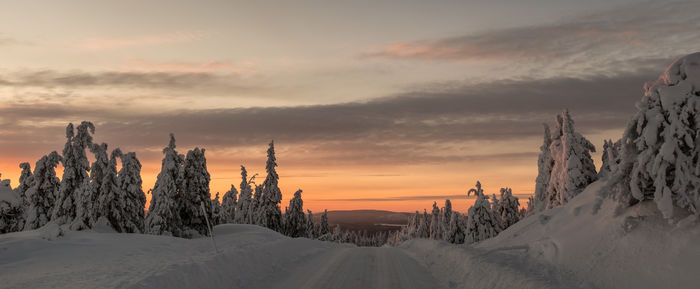 Panoramic view of snow covered landscape against sky