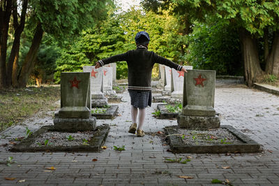 Rear view of woman standing by footpath