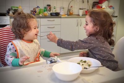 Cute baby eating food in kitchen