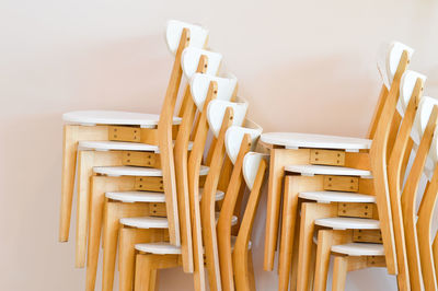 High angle view of empty chairs and table against wall