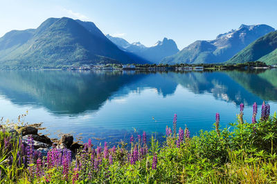 Scenic view of lake by mountains against sky