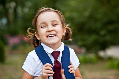 Portrait of smiling schoolgirl outdoors