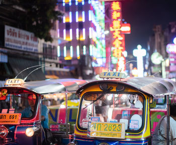 Cars on illuminated street in city at night