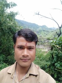 Portrait of young man against trees