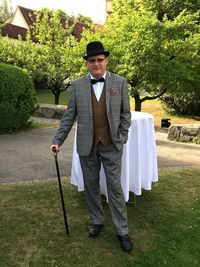 Man standing with walking cane against trees