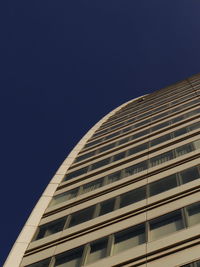 Low angle view of modern building against clear blue sky