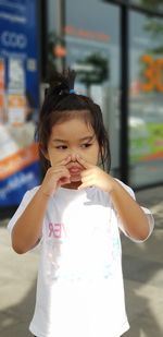 Girl looking away while standing outdoors