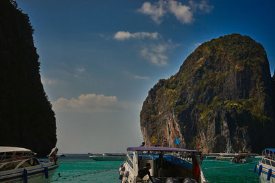 Boats moored in river against mountains