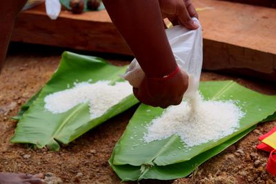 Midsection of person preparing food on leaves