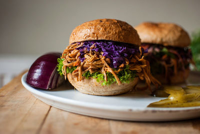 Close-up of burgers served in plate on wooden table