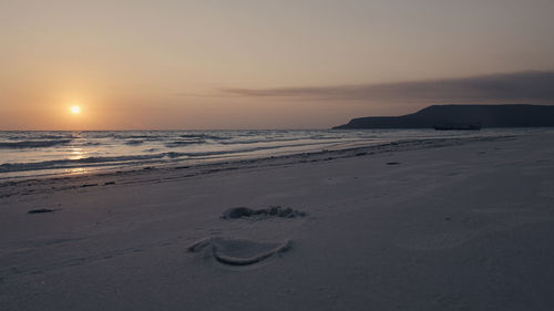 Scenic view of beach against sky during sunset