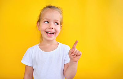 Adorable preschool girl showing pointing at copy space advertising sale announce