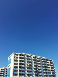 Low angle view of buildings against clear blue sky