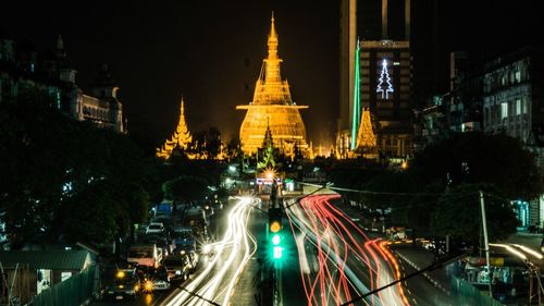 Light trails on road against illuminated pagoda