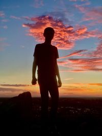 Silhouette man standing on beach at sunset