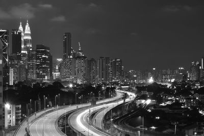 High angle view of illuminated street amidst buildings against sky