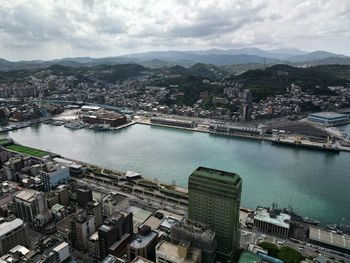 High angle view of townscape by sea against sky