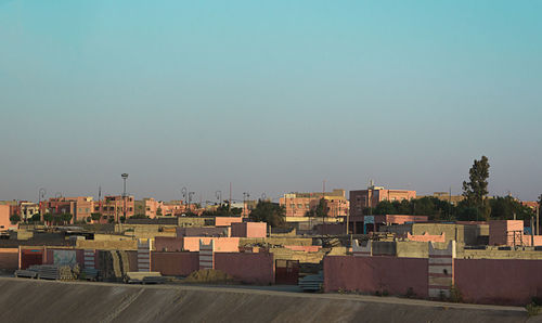 Buildings in city against clear blue sky