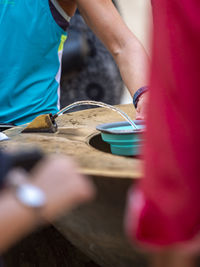 Midsection of man filling water in bowl