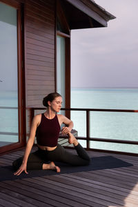 Woman exercising on pier