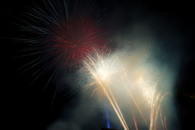 Low angle view of firework display at night