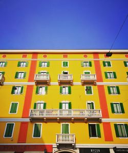 Low angle view of yellow building against sky