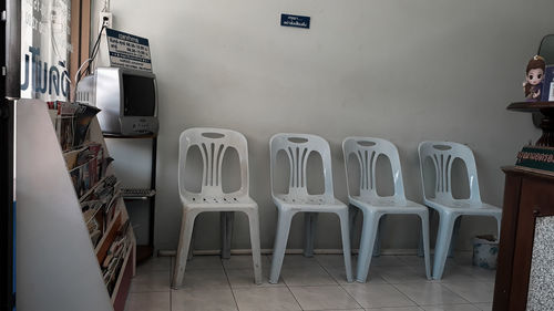 Empty chairs against wall in building