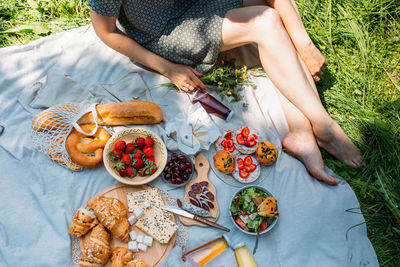 Beautiful woman on picnic. she smiles, eats strawberries and enjoys summer.