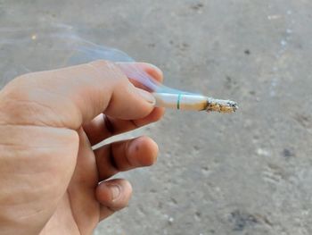 Cropped hand holding cigarette
