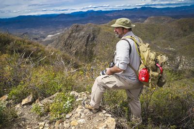 Man sitting on rock looking at mountains