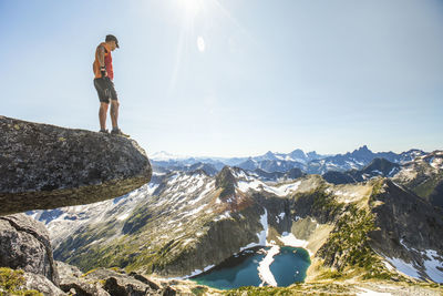 Hiker looks down at upper hanging lake from mount lindeman.