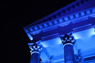 Low angle view of illuminated building against blue sky