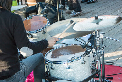 Midsection of man playing drum at outdoors