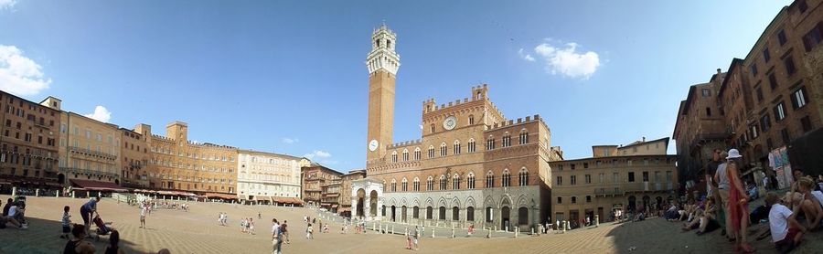 Tourists in front of building against sky