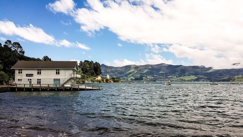 Houses by sea against sky