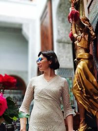 Woman standing by statue