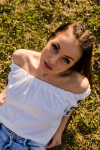 High angle portrait of beautiful woman lying on grassy field