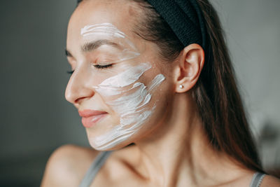 Brunette woman 30 years old with cream on her face