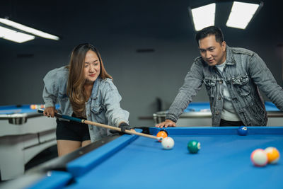 Midsection of woman playing pool