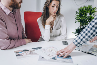 Young couple discussing over document while real estate agent explaining 