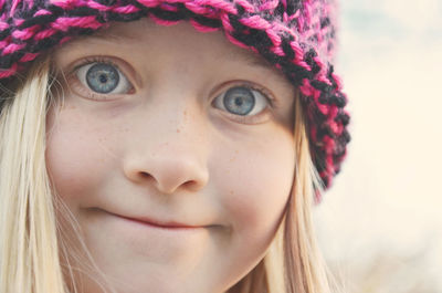 Close-up portrait of girl with blue eyes wearing knit hat